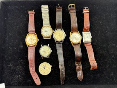 Plusieurs modèles de montres sont exposés dans une vitrine.