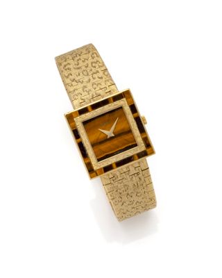 an image of a lady ' s gold watch with a tiger ' s eye