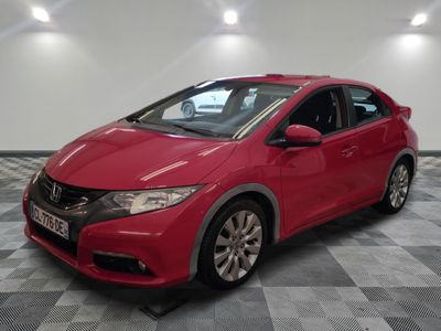 La Honda Civic rouge est garée dans une pièce dont le sol est en damier.