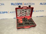 une mallette rouge contenant des outils, posée sur une table