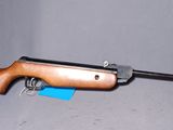 un gros plan d'un fusil sur fond blanc, avec une arme à feu au premier plan