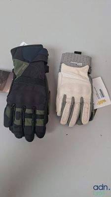 deux paires de gants posées sur une table, à côté d'un téléphone portable