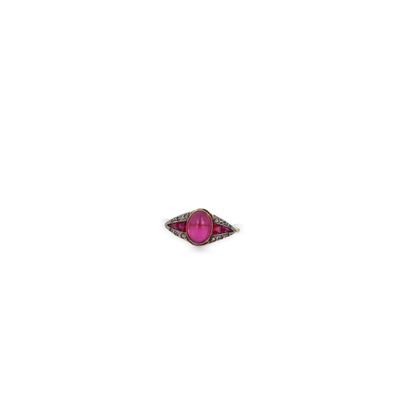 gros plan d'une bague en pierre rose sur une surface blanche