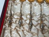five silver spoons in a red box on a white cloth