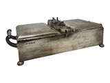 an old metal box with writing on it sitting on a white surface