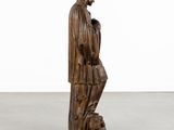 a wooden statue of a man with a bird on his shoulder
