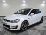 Une Volkswagen Golf R-Line blanche est garée sur un sol à damier