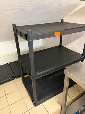 une étagère noire sur laquelle est accrochée une étiquette jaune, dans une cuisine