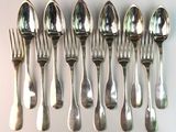 a lot of silver spoons and forks on the table