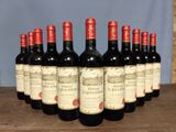 six bottles of red wine lined up in a row on a wooden table