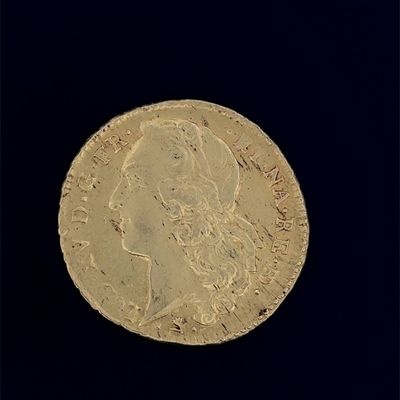 une vieille pièce d'or sur laquelle figure l'effigie d'une femme
