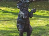 a statue of an elephant on a pedestal in the grass