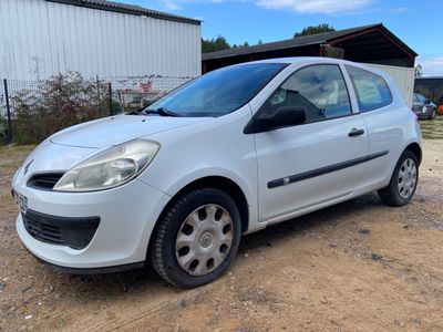 a picture of a small white car parked in a dirt lot
