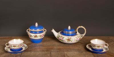 un service à thé en trois pièces, en porcelaine bleue et blanche, posé sur une table en bois