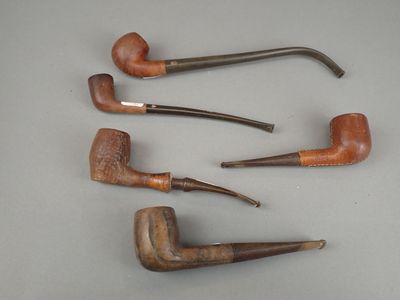 Quatre pipes sont alignées sur une table : il y en a une au milieu et une autre au milieu.