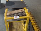 a yellow cart with a piece of wood on it
