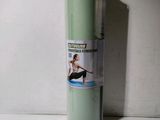 un rouleau de tapis de yoga vert posé sur une surface blanche