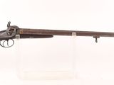 un fusil avec un canon et un embout en bois, exposé