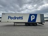 a white semi trailer parked in a parking lot with a cloudy sky