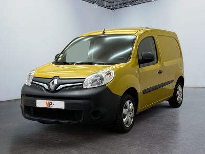 La camionnette jaune est garée dans une pièce blanche au sol noir.