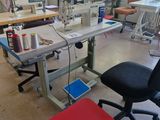 many sewing machines in a large room with a red table