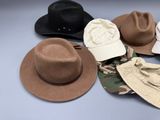 Plusieurs chapeaux sont empilés les uns sur les autres sur une table