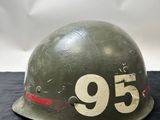 an old helmet with the number 95 on it sitting on a black surface