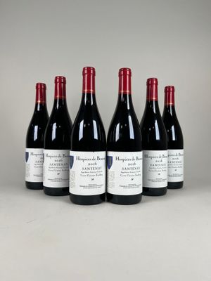 six bouteilles de vin rouge sont alignées sur une table
