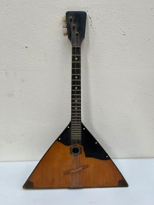 une vieille guitare accrochée au mur d'une pièce