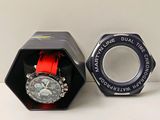 une montre dans un coffret noir avec un bracelet rouge