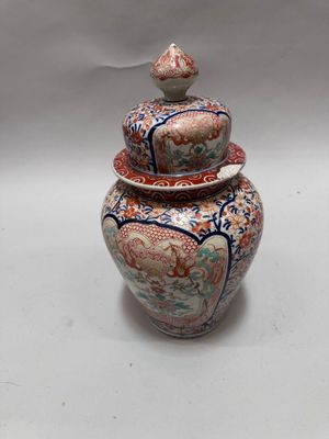a large vase with a lid sitting on a table