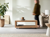 a woman standing in a living room with a coffee table