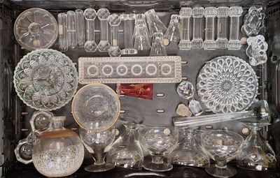 de nombreux objets en verre dans la vitrine posée sur la table