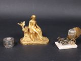 a gold statue of a woman sitting on top of a horse and carriage