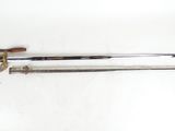 a close up of a sword with a wooden handle on a white surface