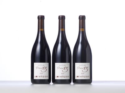 three bottles of wine are lined up on a table