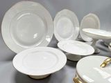 a lot of white and gold plates on a table