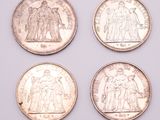 four different british coins are shown in a row on a white surface