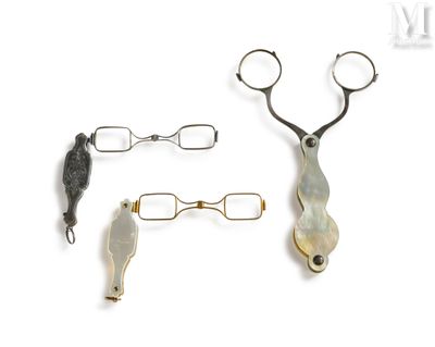 two pairs of scissors and a hair clip on a white surface