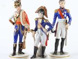 trois figurines représentant des hommes en uniforme militaire, debout les unes à côté des autres