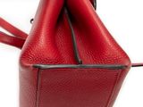 a close up of a red purse on a white surface