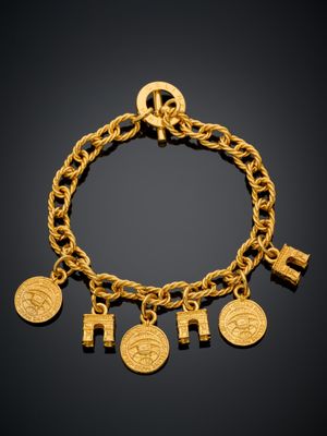 un bracelet en or orné de cinq breloques et d'une croix