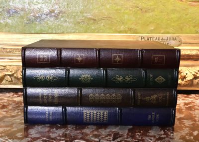 une pile de livres posée sur une table devant un tableau