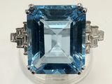 gros plan d'une bague avec une topaze bleue entourée de diamants