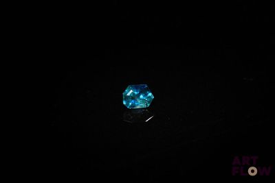 a close up of a blue diamond in the dark