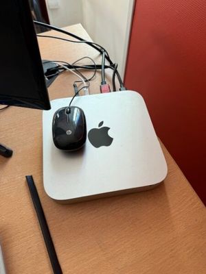 an apple computer sitting on a desk with a mouse and a monitor