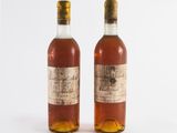 two bottles of wine sitting next to each other on a white surface