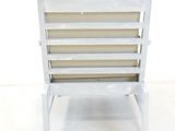 an image of a white wooden chair against a white wall