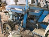 a blue tractor that is parked in a barn