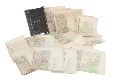 une pile de vieilles cartes et un livre posés sur une table